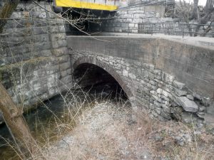 The cracked and deteriorating historic bridge before restoration.